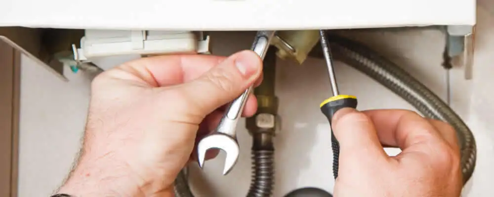 Boiler repair technician tightening pipe fittings and connections in Atlanta, GA