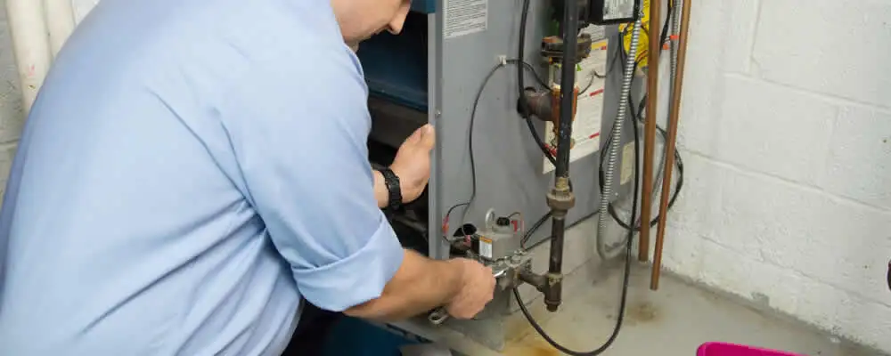 Furnace repair technician inspecting and servicing a home heating system in Atlanta, GA