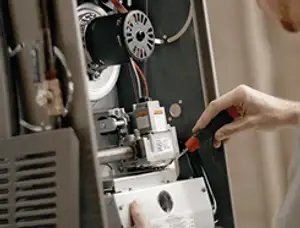 Furnace repair technician inspecting internal components and wiring in Atlanta, GA