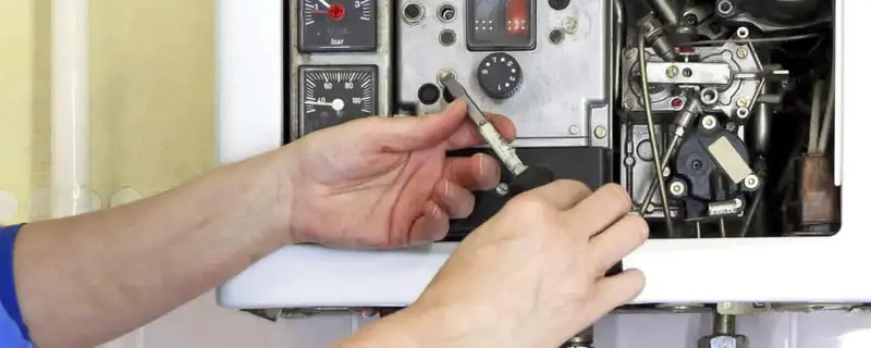 Heating repair technician adjusting boiler controls and components in Atlanta, GA