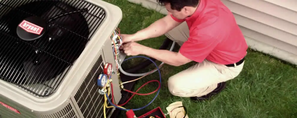 HVAC technician servicing an outdoor air conditioner unit in Atlanta, GA
