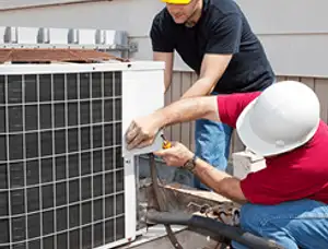 HVAC technicians repairing an outdoor AC unit on a rooftop in Atlanta, GA