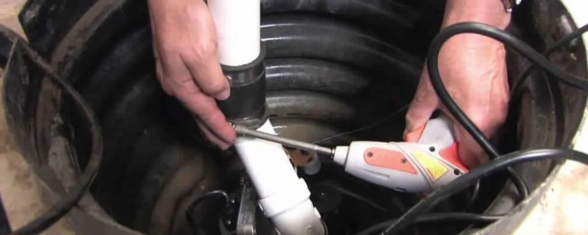 Sump pump installation technician connecting PVC discharge piping in Atlanta, GA