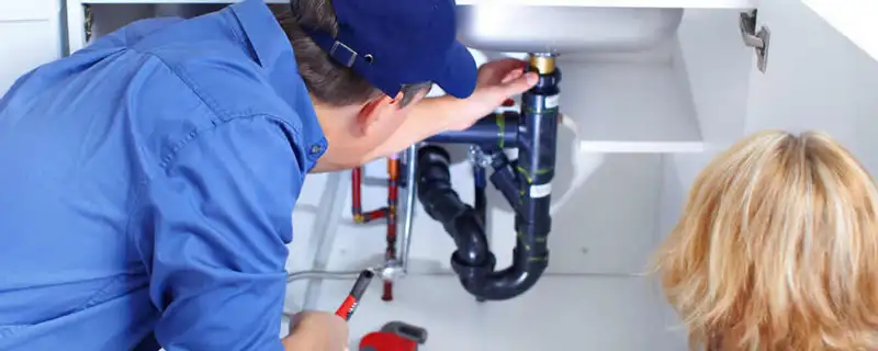 Plumber repairing under-sink drain pipes and fittings in Atlanta, GA